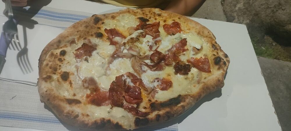 Pizza bianca con provola e prosciutto crudo appena sfornata